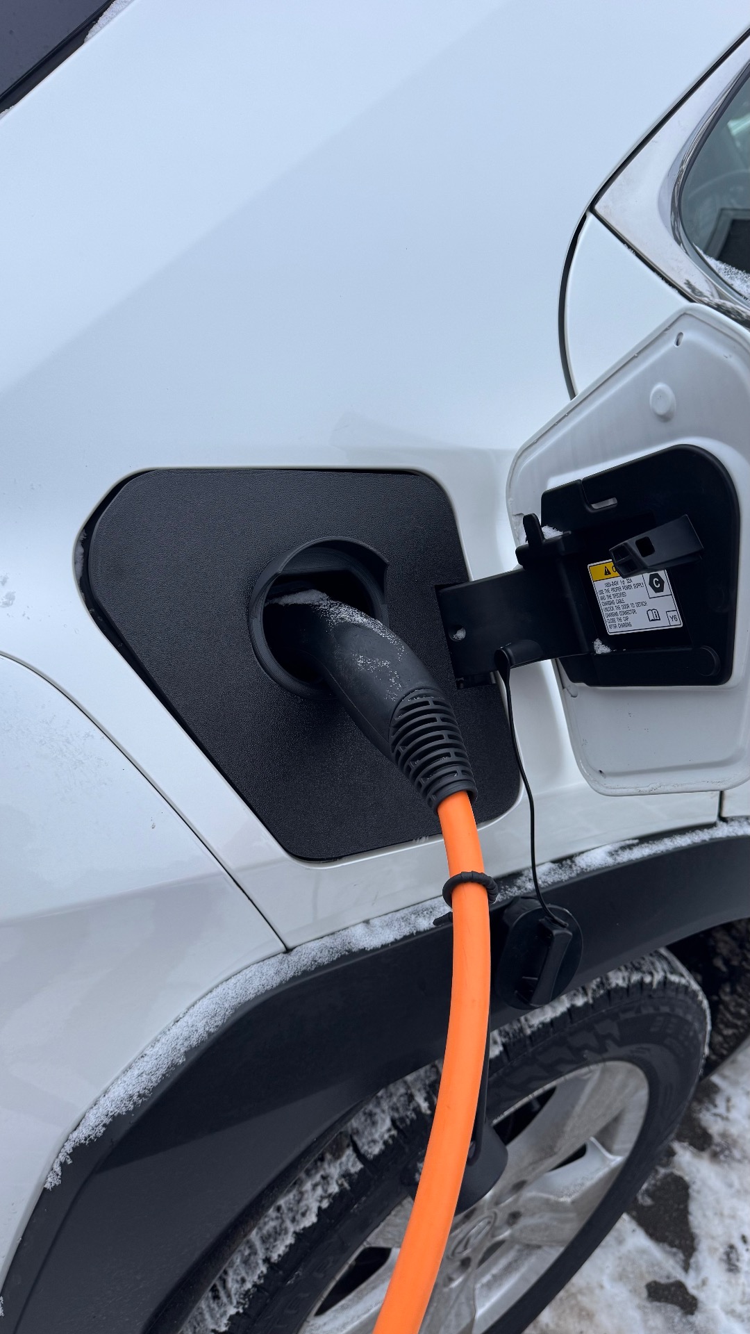 Ladedeksel montert på Lexus UX 300e under lading, gir beskyttelse av ladeporten ved utendørs lading